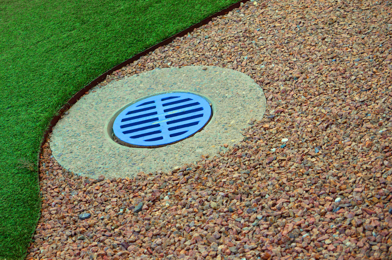 abstract-composition-of-blue-sewer-cover-on-gravel-2025-10-28-21-38-38-utc