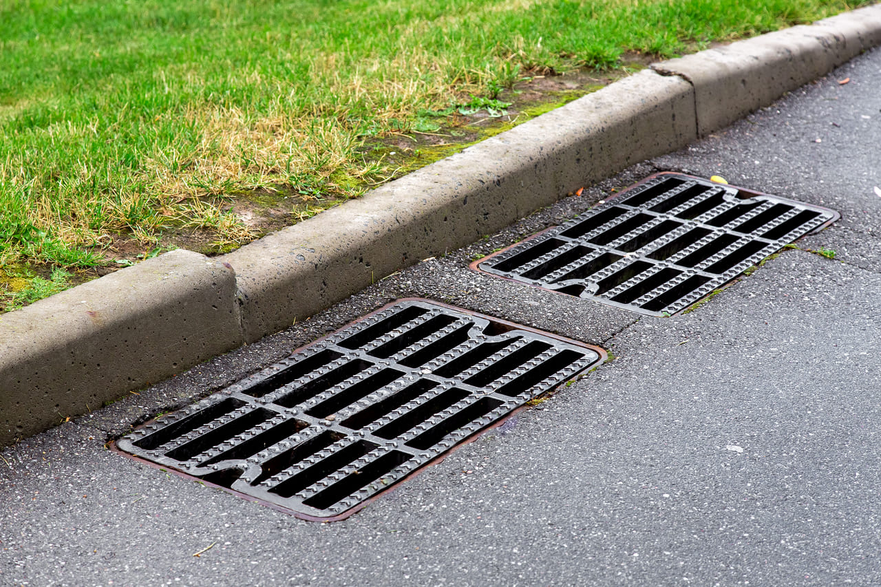 manhole-cover-rain-grate-on-an-asphalt-road-near-a-2025-10-10-12-41-54-utc